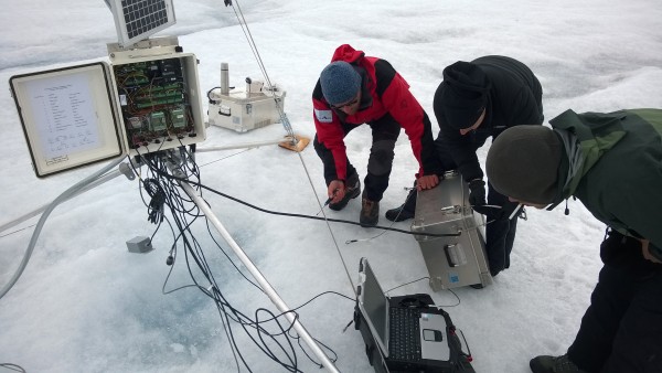 Researchers service one of PROMICE’s automatic weather stations on the Greenland ice sheet that was used in the study. Photo by William Colgan, York University