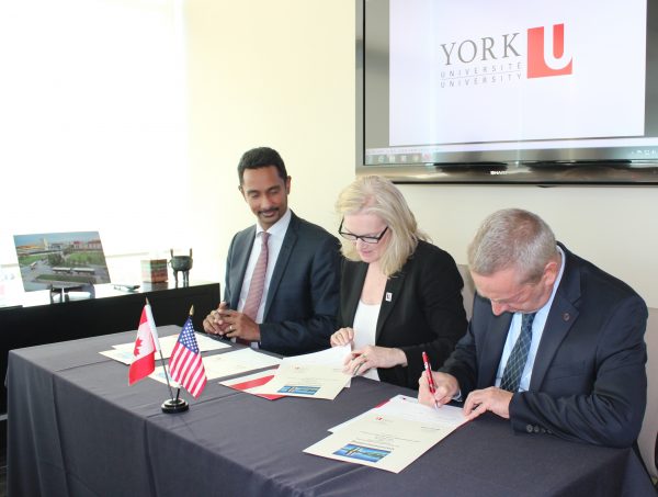 image of York U Faculty of Science Dean, York U President and Director of Fermilab Nigel Lockyer signing an MOU