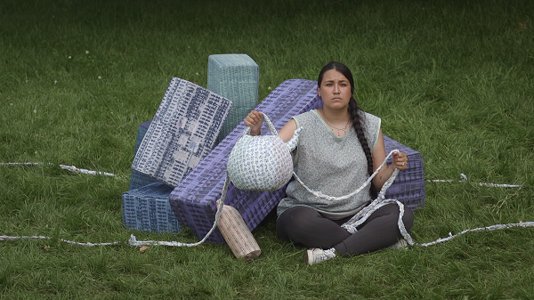 Woman sitting on grass holding basket